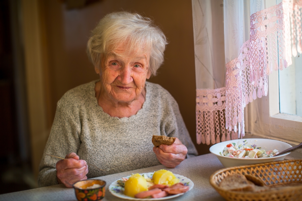 Elderly lady eating at her table